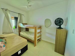 Habitación pequeña con litera y espejo. en Bela acomodação em jacuipe com churrasqueira, piscina, mesa de sinuca e três quartos, dois sendo suítes! Além de muito espaço por toda a área!, en Barra do Jacuípe 23 fotos más