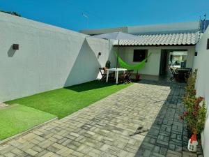 un patio con mesa y sillas en un patio trasero en Bela acomodação em jacuipe com churrasqueira, piscina, mesa de sinuca e três quartos, dois sendo suítes! Além de muito espaço por toda a área!, en Barra do Jacuípe