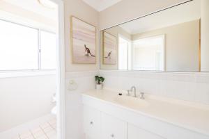 a white bathroom with a sink and a mirror at Bushmans, 9 24 Tomaree Street - Spacious townhouse with air conditioning and close to Nelson Bay Town Centre in Nelson Bay +14 photos