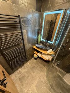 a bathroom with a sink and a shower with a mirror at Apartmán Horský Sklípek in Trutnov +17 photos