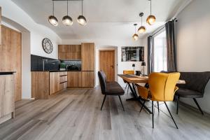 a kitchen and dining room with a table and chairs at Apartmán Horský Sklípek in Trutnov