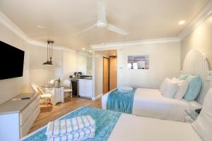 a hotel room with two beds and a television at SeaVenture Beach Hotel in Pismo Beach