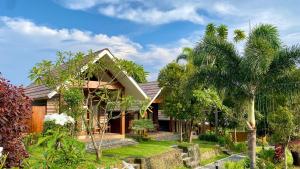 ein Haus mit Palmen davor in der Unterkunft Pondok Senaru Cottages in Senaru