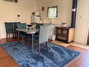 a dining room with a table and chairs and a kitchen at Convent at Koroit in Koroit