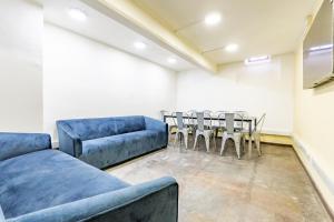 サンティアゴにあるHabitación en Providencia - Metro Baquedanoの青いソファ、テーブルと椅子が備わる客室です。
