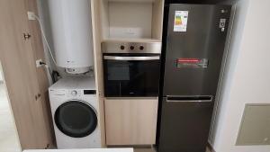 Il comprend une petite cuisine équipée d'un réfrigérateur et d'un lave-linge. dans l'établissement Modern Apartamento con Suites - Centro de Temuco, à Temuco