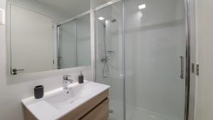 une salle de bain blanche avec un lavabo et une douche dans l'établissement Modern Apartamento con Suites - Centro de Temuco, à Temuco