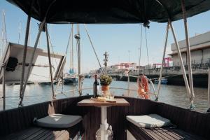 a table and chairs on a boat in the water at Cozy Lisbon Marina Sleepaboard - Sail Away in Lisbon