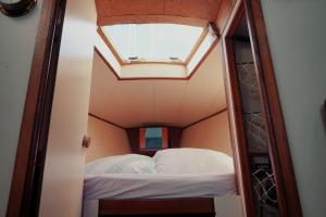 a small bed in a small room with a skylight at Cozy Lisbon Marina Sleepaboard - Sail Away in Lisbon