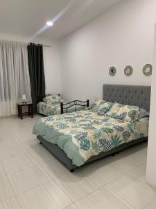a bedroom with a bed with a comforter on it at Hermosa casa de descanso in Ricaurte