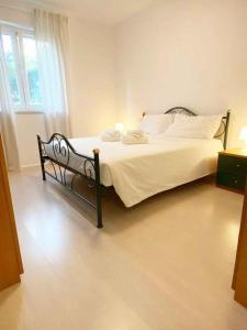 a bedroom with a bed with white sheets and pillows at Apartment in Funtana - Istrien 53415 in Funtana