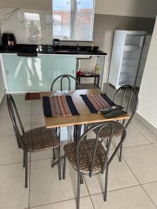 a table and chairs in a kitchen with a counter at Residencial Mangueiral in Paracatu