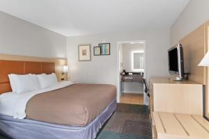a hotel room with a bed and a flat screen tv at Richland Inn of Columbia in Columbia +36 photos