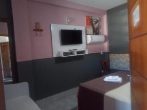 a room with a tv on a wall with a table at Hotel Pousada Villa Monnaié centro in Chapada dos Guimarães +27 photos