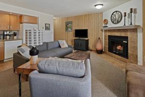 Una sala de estar con un sofá y una chimenea. en Ski Condo 151, en Bend