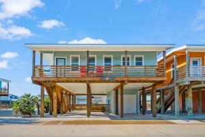 a house on wooden posts with a balcony at No Regrets PET FRIENDLY in Port Aransas