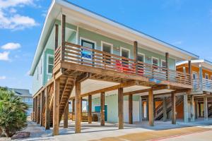 a house with a deck on the side of it at No Regrets PET FRIENDLY in Port Aransas