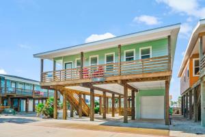 a house with a deck on a street at No Regrets PET FRIENDLY in Port Aransas