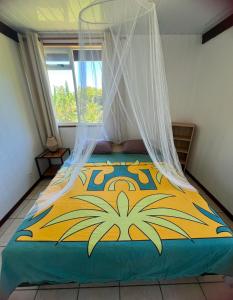 a bedroom with a bed with a mosquito net at Maupiti Vaitia Lodge in Maupiti