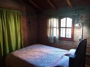 a bedroom with a bed and a window at Casita Loma Hermosa in Mina Clavero