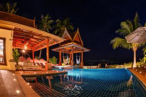 a resort with a swimming pool at night at Sun and Sand Beachfront Pool Villa in Koh Phangan