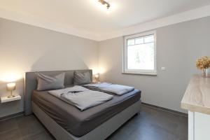 a bed in a white room with a window at unter den Kiefern 98 EG in Marienfelde