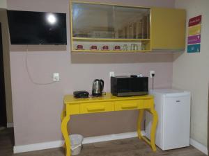 a yellow table with a microwave on top of it at Loft Confort in Pomerode