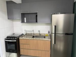 een keuken met een roestvrijstalen koelkast en een spoelbak bij Lazer completo e vista inesquecível in Guarujá
