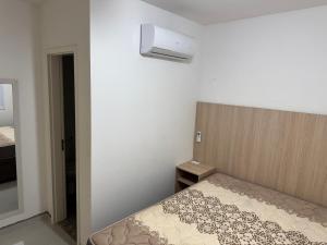 een slaapkamer met een bed met een hoofdeinde en een licht bij Lazer completo e vista inesquecível in Guarujá +39 foto's