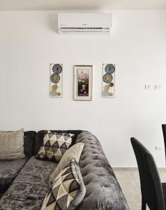a living room with a couch and a white wall at Fontana del Valle Condominio 156 in San Pedro Sula +39 photos