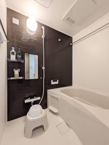 a bathroom with a white toilet and a bath tub at THE TERRAce HAKATA in Fukuoka +13 photos