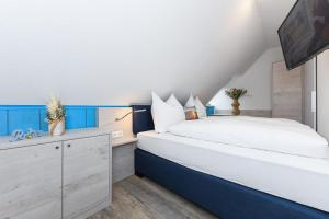 Un dormitorio con una cama grande con detalles en azul. en Strandkorb 4, en Bensersiel 15 fotos más