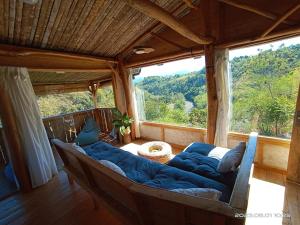 a large couch in a room with a large window at Tanawatu Hill in Poma