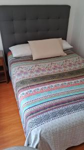 a bed with a black headboard and a blanket at El Derby 511 Aparts de 3 Dorm con Aire Acondicionado in Lima