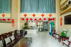 un hall d'entrée avec des chaises et un panneau sur le mur dans l'établissement VICTORY SECC Hotel, à Hô-Chi-Minh-Ville