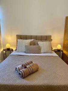 a bed with a rolled up towel on it at Estúdio no centro de Friburgo in Nova Friburgo