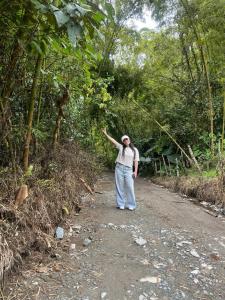 Człowiek idący po polnej drodze z ręką w górze w obiekcie Coffee Tour, Colombia Aranzazu Caldas- Andean Motmot coffee w mieście Aranzazu