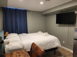 a bedroom with a bed with a tv on the wall at May Flowers in Kingston