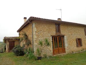 a small stone house with a large wooden door at Gite Tauzia in Brassempouy
