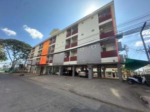 un edificio de apartamentos al costado de una calle en Wellington Apartment, en Ban Nong Waeng