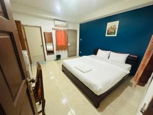 Un dormitorio con una cama grande con una pared azul. en Wellington Apartment, en Ban Nong Waeng 8 fotos más