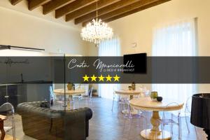 a restaurant with tables and chairs and a chandelier at B&B Costa Masciarelli - Suite affrescate a due passi dal Duomo in LʼAquila