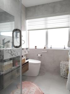 a bathroom with a toilet and a sink and a window at Dream home in Auckland