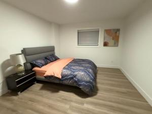 a bedroom with a bed and a lamp in a room at Calm & Cozy Private Suite in Surrey +2 photos