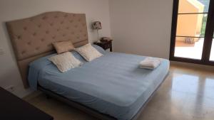 a bed with two pillows on it in a bedroom at Las Jacarandas Penthouse with Stunning Views & Private Rooftop in Benahavís