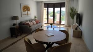 a living room with a table and a couch at Las Jacarandas Penthouse with Stunning Views & Private Rooftop in Benahavís