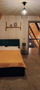 a bedroom with a large bed with a yellow blanket at Cabana Alive - Colibita in Colibiţa