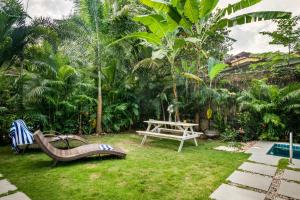 a garden with benches and a table and a picnic table at Casa, Anjuna villa Vagator, with Pvt pool in Vagator