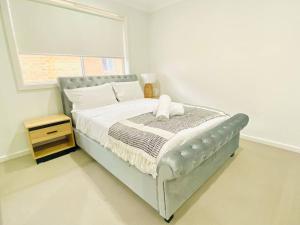 Un dormitorio con una cama con un osito de peluche encima. en Kellyville 5Br Near park and shopping mall, en Kellyville