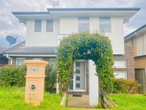 una casa blanca con un arco sobre la puerta principal en Kellyville 5Br Near park and shopping mall, en Kellyville